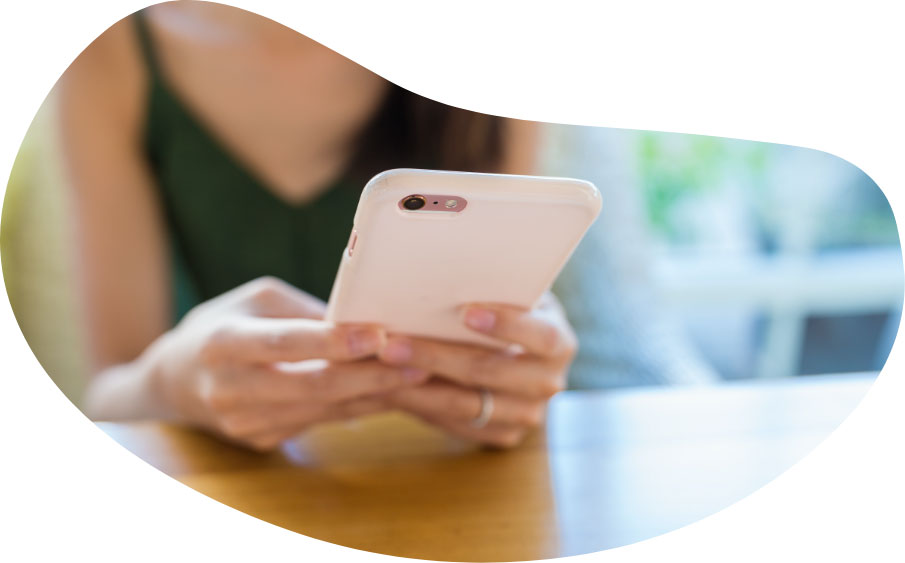 Close up of the back of a woman's hands and her white smartphone